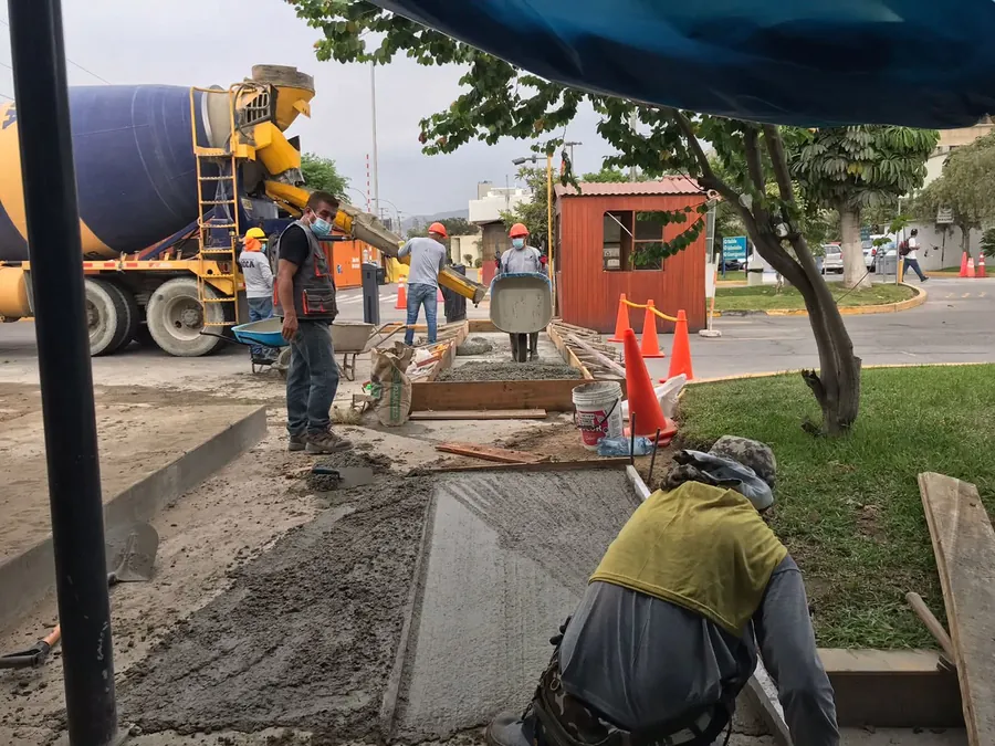 Cuadrilla terminando vereda de concreto